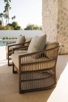 three wicker couches sitting next to each other on a patio with palm trees in the background