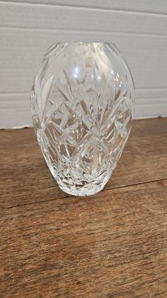 a clear glass vase sitting on top of a wooden table