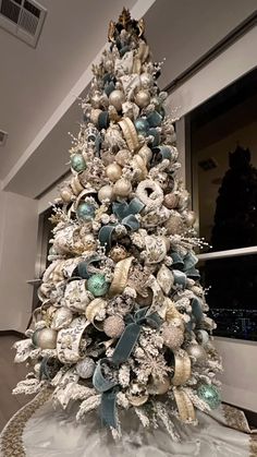 a white christmas tree with blue and silver ornaments