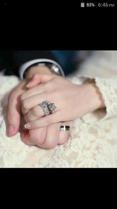 two people holding hands with wedding rings on their fingers and the other hand is wearing an engagement ring