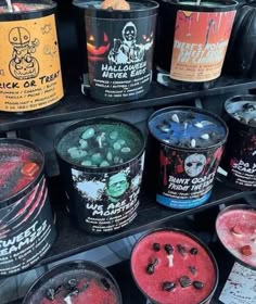 many different colored ice creams in buckets on a display shelf with sprinkles