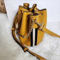 Authentic Bally Mustard Leather Nwot Bucket Bag. Has Black And White Stripe On Each Side. Gold Hardware. Detachable Adjustable Crossbody Strap. Comes With Care Card, Dust Bag, And Paper Bag! Size Is 7” W X 7” H All My Items Are From A Smoke Free Home. If You Have Any Questions Feel Free To Reach Out. Thank You For Looking Elegant Yellow Bucket Bag With Top Handle, Elegant Yellow Top Handle Bucket Bag, Elegant Gold Bucket Satchel, Yellow Bucket Bag With Gold-tone Hardware, Yellow Leather Shoulder Bag With Branded Hardware, Classic Gold Bucket Shoulder Bag, Elegant Yellow Bucket Bag With Removable Pouch, Chic Gold Bucket Satchel, Elegant Yellow Bucket Bag For Daily Use