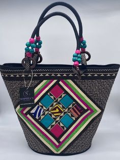 These beautiful handbags are made from Cana Flecha which is an indigenous palm fiber found in the northern territory of Colombia. They are beautifully hand crafted by the people from the Zenu tribes in Colombia. These handbags are colorful with vibrant colors, which is a pure reflection on the region and the warmness of these master artisans that work in this industry every day. Traditional Black Rectangular Bag, Traditional Black Rectangular Shoulder Bag, Traditional Rectangular Bag With Handles, Traditional Rectangular Bags With Handles, Traditional Black Handheld Bag, Traditional Shoulder Bag With Handles, Daily Use Fair Trade Jute Bag, Traditional Handmade Black Shoulder Bag, Fair Trade Tote Bag For Vacation