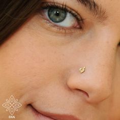 a close up of a woman's face with a nose pin in the middle