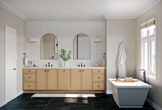 a bathroom with two sinks, mirrors and a bathtub next to a large window