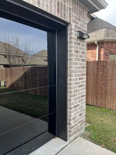 an open garage door in front of a brick building