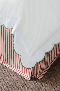 a bed with red and white striped bedspread on it's bottom half