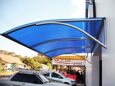 cars are parked under a blue awning