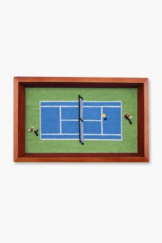 a cross stitch tennis court with two racquets on it