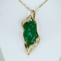 Discover the allure of our unique and elegant designer pendant. This extraordinary piece showcases a large natural Colombian cabochon emerald, exquisitely adorned with round brilliant cut diamonds. The diamonds, beautifully accentuate the breathtaking emerald. Crafted in 14K yellow gold, this pendant is a testament to exceptional craftsmanship and timeless elegance. Make a statement with this one-of-a-kind masterpiece that effortlessly captures attention and admiration. SPECIFICATIONS: 1982658 Gemstone: Natural Colombian Emerald, cabochon. Weight: 17.0ct.  Side Stones: 0.65ct of various sizes round brilliant cut diamonds. Colour: F G. Clarity: SI Material: 14K yellow gold. Total Weight: 13.34 grams. Dimensions: 50.0 x 21.0mm approx. Our family-owned business consists of gemmologists, miner Luxury Diamond Jewelry With Cabochon Cut, Luxury Cabochon Diamond Jewelry, Exquisite Green Jewelry With Pave Setting, Exquisite Emerald Jewelry With Cabochon, Exquisite Emerald Cabochon Jewelry, Luxury Green Cabochon Jewelry, Luxury Jade Necklace For Formal Occasions, Luxury Formal Jade Necklace, Diamond Cabochon Necklace For Anniversary