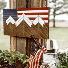 an american flag is hanging on the side of a wooden fence with other items around it