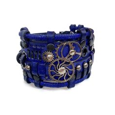 This blue leather bracelet looks absolutely stunning. It is designed for men and women who love steampunk or cyberpunk fashion trends.  It was made of genuine leather and decorated with metal parts Bracelet's width is about 2 in (5 cm) Bracelet's length is about 7.9 in (20 cm) It fits the wrist 7.1-8.3 in (19-22 cm) Please measure your wrist to make the correct choice  IMPORTANT - since it's a handmade item there might be slight variations in the design, however, the general idea and impression will be preserved. CARE No special care is required. Avoid chemical exposure including perfumery. If you need a custom order please let me know and I will try to do my best to prepare it for you:) If you have any questions feel free to ask.  Thank you for choosing shop Adjustable Steampunk Leather Bracelet, Blue Leather Bracelets For Festival, Blue Leather Festival Bracelets, Leather Punk Cuff Bracelet For Festival, Adjustable Blue Leather Cuff Bracelet, Unique Blue Cuff Bracelet For Festival, Punk Leather Strap Bracelets, Handmade Blue Leather Bracelet For Festival, Handmade Blue Leather Festival Bracelet