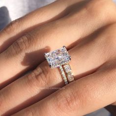 a woman's hand with two engagement rings on it and one diamond ring in the middle