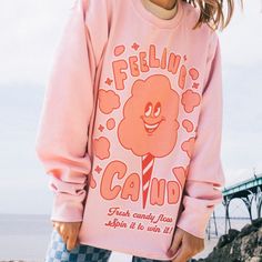 Women's printed sweatshirt with “Feeling Candy” slogan and vintage style candy floss character graphic. Spin it to win it in this retro candy floss slogan sweater. Super-comfy, oversized fit. This item makes a great gift and it's a must-have for your summer staycation wardrobe. All Batch1 products are lovingly designed, printed and packed by hand in the UK at Batch1 HQ.  Our garments are made to order to minimise wastage and printed using water-based, eco-friendly inks. We are committed to creat Pink Letter Print Tops For Leisure, Oversized Cartoon Print Sweatshirt, Trendy Oversized Cartoon Print Sweatshirt, Leisure Pink Tops With Letter Print, Oversized Cartoon Print Trendy Sweatshirt, Winter Fun Sweatshirt With Cartoon Print, Fun Winter Sweatshirt With Cartoon Print, Spring Cartoon Print Relaxed Fit Sweatshirt, Graphic Print Long Sleeve Sweater For Loungewear