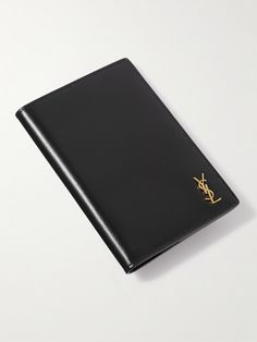 Made in Italy from glossed black leather, SAINT LAURENT's 'Cassandre' passport cover is the ultimate airport upgrade. The bi-fold design opens up to reveal two inserts and four card slots. It’s detailed with a gold-tone YSL emblem at the front and the Saint Laurent Paris logo on the inside. Ysl Paris, Ysl Wallet, Leather Billfold, Paris Logo, Leather Passport Holder, Passport Case, Leather Passport Cover, Billfold Wallet, Passport Wallet