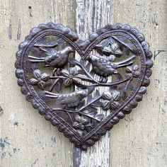 a heart shaped metal decoration with birds on it