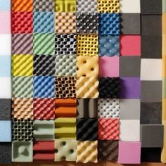 many different colored squares are arranged on the wall with holes in each one to make them look like they have been made out of legos