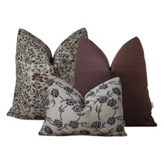 three pillows with different designs on them, one in brown and the other in blue