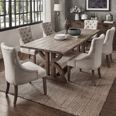 a dining room table with white chairs around it