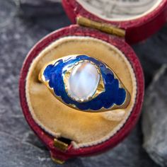 This ethereal ring is centered with an oval gem-quality moonstone cabochon. The moonstone glows atop the dark blue enamel accented shoulders. The ring has a Swiss "Three Crown" stamp. It is crafted in 18K yellow gold and is now and forever a size 9. Please note that there is some jeweler's epoxy exposed from setting the moonstone. Due to the enamel details of this ring, we are not offering resizing on this piece. Collectible Oval Cabochon Moonstone Ring, Celestial Oval Cabochon Rings, Heirloom Oval Moonstone Ring, Antique Oval Moonstone Ring Collectible, Celestial Hallmarked Jewelry With Oval Stones, Celestial Style Hallmarked Oval Jewelry, Elegant Blue Oval Cabochon Moonstone Ring, Celestial Oval Cabochon Moonstone Ring, Oval Cabochon Moonstone Ring In Fine Jewelry Style