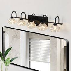 a bathroom vanity with three lights and a mirror