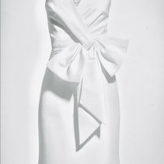 a white dress with a large bow on the front and back, is shown in black and white