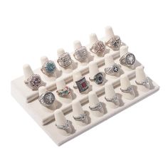 an assortment of rings is displayed on a white display stand with multiple sizes and shapes