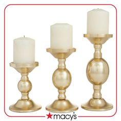 three gold candlesticks with white candles in them