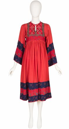 "This 1970s Karmelle Afghan-inspired dress was made in India of red rayon with striped blue and red floral trim. The waistband is pleated and the neckline is hard-embroidered. It slips over the wearer's head and fastens with a button at the neckline. It's in very good condition, clean and ready to wear. Measurements: Bust - 33\" Waist - 32\" Hips - open Shoulders - 12\" Sleeves - 22\" Length - 44.5\"" Red Folk Style V-neck Dress, Red Folk Dress With Embroidered Border, Folk Style Red Dress With Embroidered Border, Red Vintage Dress With Floral Embroidery, 1970 Fashion, Afghan Dresses, Silk Twill, Inspired Dress, Mode Fashion