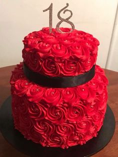 a red cake decorated with roses and the number eighteen on top is sitting on a table