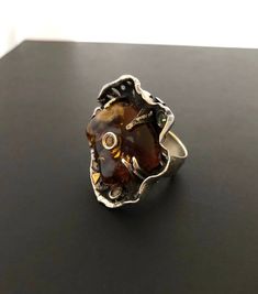 "ARTISAN AMBER RING Hand-made Sterling Silver. Size 8-8 1/2 Stones used: Baltic Amber, Green&Pink Tourmaline, Yellow Sapphire. Face of the ring : Height - 35mm, Width-35mm Height - 1 3/8\", Width - 1 3/8\" Stone size on the ring face - Height-27mm, Width-24mm. It is a very Unique Ring - a Spinner Ring, You can spin it around and wear any way you want. Unique Handcrafted One-of a-kind Design Ring. Each Piece of Jewelry in my Collection is One of a kind. When you start wearing a piece of my je Handmade Amber Rings In Fine Jewelry Style, Luxury Amber Rings As Gifts, Luxury Amber Ring As Gift, Unique Sterling Silver Oval Ring, Unique Oval Sterling Silver Rings, Fusion Style Polished Finish Rings As Gift, Luxury Amber Rings For Gift, Handmade Unique Rings For Formal Occasions, Unique Handmade Formal Rings