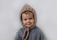 a young child wearing a knitted hat and scarf