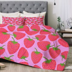 a bed with pink and green strawberry print on it