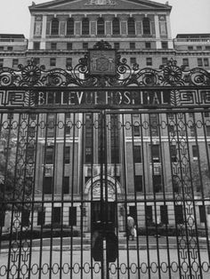 an old building with a large iron gate and clock on it's front entrance