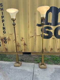 two lamps sitting next to each other in front of a wall with the number 50 on it