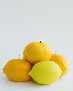 a pile of lemons sitting next to each other on top of a white table