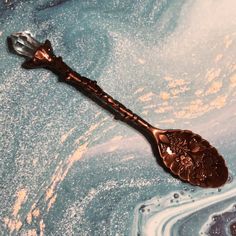 a metal spoon sitting on top of a blue and white countertop covered in water