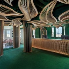 the interior of a restaurant with green carpet and wooden columns