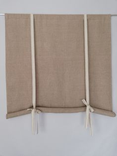 three pieces of fabric tied together on a white wall with two ties hanging from the side