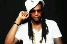 a man with long dreadlocks wearing a white hat and sunglasses, holding his hand to his ear