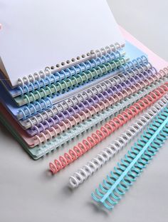 several different colored spiral binders on top of each other