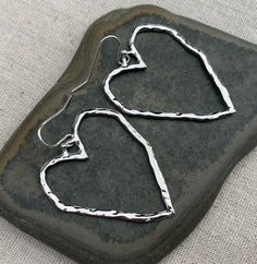 "Big, bold and chic! Open silver heart earrings are simple and stylish. These earrings make a statement about love, peace and happiness. They would make an awesome gift for a loved one too. The earrings measure 1 1/2\" long by 1 1/4\" wide. They hang from simple silver ear wire hooks. Overall drop length is 1 5/8\". Made from allergy free plated silver. I have a matching necklace in my shop if you would like the whole set. Here is a direct link https://etsy.me/3sYR0xv Thanks for stopping by! Ple Modern Sterling Silver Heart Earrings For Gift, Modern Heart Earrings With Heart Charm As A Gift, Modern Heart Charm Earrings As Gift, Modern Heart Charm Earrings For Gift, Modern Heart-shaped Earrings For Anniversary, Modern Heart-shaped Hoop Earrings For Gift, Modern Heart-shaped Hoop Earrings Gift, Nickel-free Minimalist Open Heart Earrings, Minimalist Nickel-free Open Heart Earrings