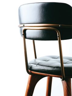 a black leather chair sitting on top of a wooden stool