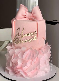 a pink cake with a bow on top