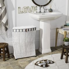 a white sink sitting next to a mirror on top of a bathroom wall above a toilet