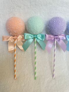 three lollipops with bows on them are lined up next to each other