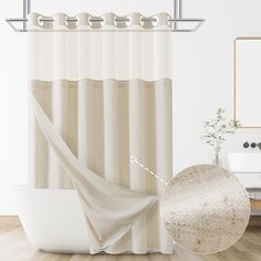 a bathroom with a bathtub, shower curtain and round rug on the wooden floor