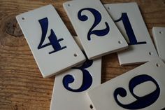 four white and blue house numbers on a wooden table