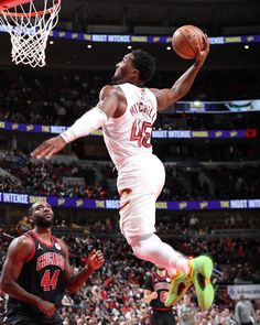 a man dunking a basketball during a game