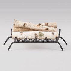 a bench made out of logs with metal legs and black frame on the bottom, in front of a gray background